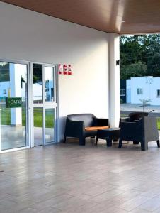 a lobby with couches and chairs in front of a building at The small house in Ahuachapán