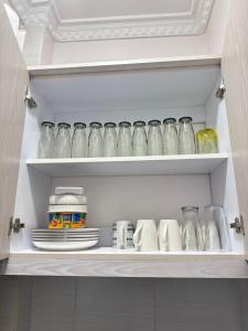 a cupboard filled with glass jars and plates at Beytumn Luxury Apartment - Ruiru in Nairobi