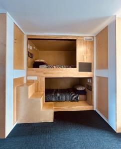 a room with a bunk bed with wooden shelves at Finlay Jack's Backpackers in Taupo