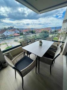a dining room with a table and chairs and a large window at Apartment Zoe in Tivat