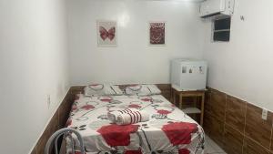 a small bedroom with a bed with a comforter at Pousada Carimbó in Fortaleza +18 photos