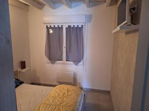 a bedroom with a bed and a window at Petite maison calme in Queyrac +6 photos