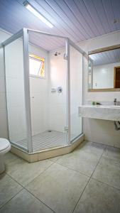 a bathroom with a shower and a sink and a toilet at Meu Hotel Boituva in Boituva
