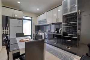 a kitchen with a dining table and a kitchen with appliances at Vilamar- Madeira Inn Group in Calheta