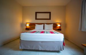 a bedroom with a large bed with two pillows at Meu Hotel Boituva in Boituva