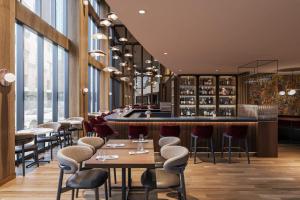 a restaurant with tables and chairs and a bar at Metcalfe Hotel Montréal by Gray Collection in Montreal