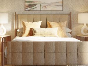 a large bed with a wooden headboard in a bedroom at Shore Haven Inn in Falmouth
