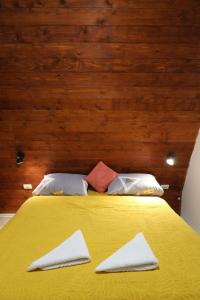 a yellow bed with two white towels on it at Panta Nature House in Dobrodoli