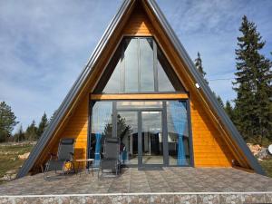 a house with a triangular roof with glass windows at Panta Nature House in Dobrodoli