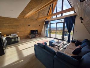 a living room with a blue couch and a large window at Panta Nature House in Dobrodoli