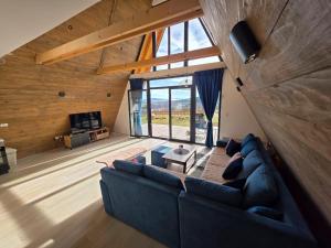 a living room with a blue couch and a large window at Panta Nature House in Dobrodoli