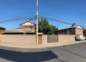 a building on the side of a street with a fence at Hostal JV CABAÑA in Nogales