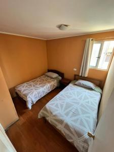 a bedroom with two beds and a window at Hostal JV CABAÑA in Nogales