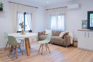 ein Wohnzimmer mit Sofa, Tisch und Stühlen in der Unterkunft Ca l'Eli Caseta in Montblanc