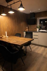 a wooden table in a kitchen with chairs and lights at Slava Spa Relax House in Nakskov
