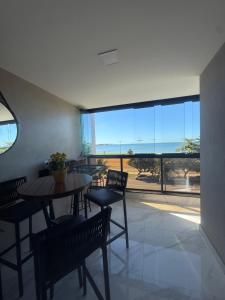 a dining room with tables and chairs and a large window at Apartamento del sole in Vitória