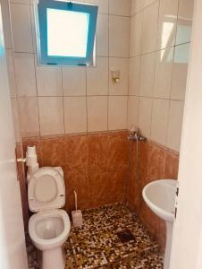 a bathroom with a toilet and a sink and a window at Rozana Rooms in Ulcinj +107 photos