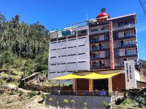 a building with a man sitting on top of it at Hotel El Castor in Huaraz