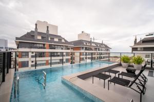a swimming pool on the roof of a building at Jurerê Sol&Mar Temporada in Florianópolis