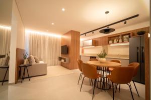 a kitchen and living room with a table and chairs at Jurerê Sol&Mar Temporada in Florianópolis
