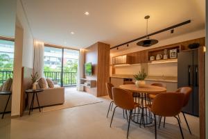 a kitchen and living room with a table and chairs at Jurerê Sol&Mar Temporada in Florianópolis