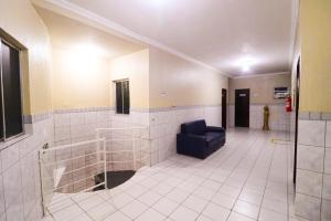 a bathroom with a blue chair in a room at Pousada Dom Manuel - Ce in Fortaleza