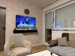 a living room with a couch and a tv on a wall at Vikendica Katarina in Šipovo