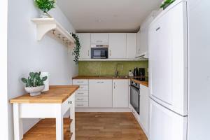 a kitchen with white cabinets and a wooden table at Apartment in the heart of Bergen in Bergen