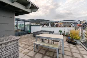 a patio with a table and a bench on a roof at Apartment in the heart of Bergen in Bergen
