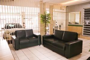 two black leather chairs in a room with a car at Pousada Dom Manuel - Ce in Fortaleza