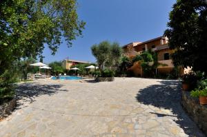 a large courtyard with a pool and umbrellas at Egli Apartments in Kontokali