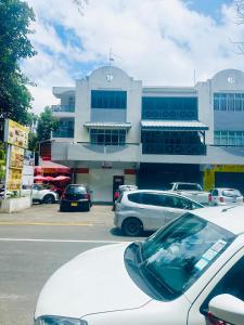 a parking lot with cars parked in front of a building at Pereybere Beach Home in Pereybere +1 photo