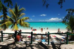 a group of people on a beach with the ocean at Pereybere Beach Home in Pereybere