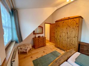 an attic room with a bed and a wooden cabinet at Kaiserstube in Quedlinburg