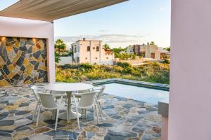a patio with a table and chairs next to a pool at Casa Arroyo Pacific in Todos Santos