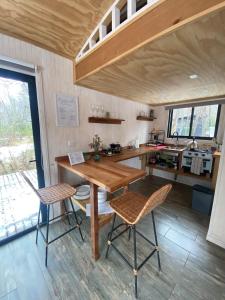 a kitchen with a wooden table and two chairs at Tiny House en Malalcahuello - Tranquilidad total in Malalcahuello