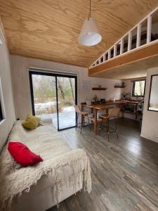 a bedroom with a bed with a red pillow on it at Tiny House en Malalcahuello - Tranquilidad total in Malalcahuello