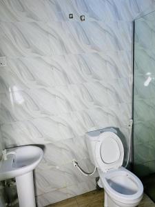a bathroom with a toilet and a sink at Wesmont Hotels in Ikorodu +20 photos