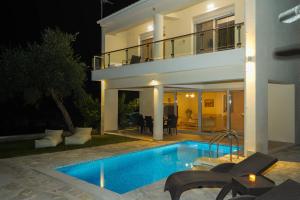 a villa with a swimming pool at night at Pargamaisonnette in Parga