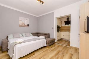 a bedroom with a bed and a couch at Apartments Serzane in Zastražišće