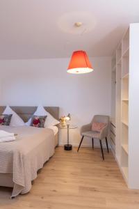 a bedroom with a bed and a chair and a lamp at Buhlbach, Black Forest Retreat, mit Sonnenterrasse in Baiersbronn