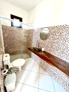 a bathroom with a toilet and a glass shower at Casa da Juma in Fortim +84 photos