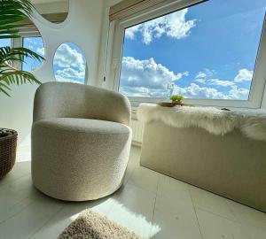 a living room with a chair and a window at BEACH apartment met directe toegang tot het STRAND ! in Knokke-Heist