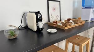 a black counter top with a coffee maker and a box at Habitaciones IFAE in Alcalá