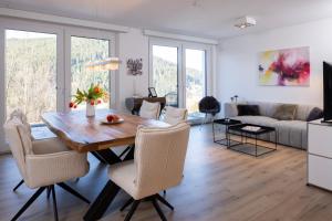 a dining room and living room with a table and chairs at Buhlbach, Black Forest Retreat, mit Sonnenterrasse in Baiersbronn
