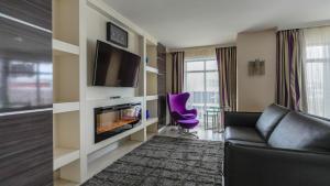 a living room with a couch and a tv at Hôtel Palace Royal Centre-Ville Québec par JARO in Quebec City