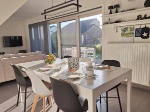 a white dining table and chairs in a living room at Maison Maritime in Middelkerke +17 photos