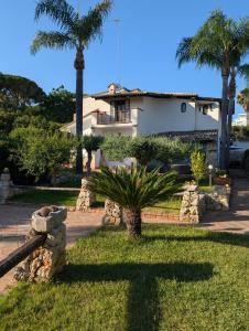 a palm tree in front of a house at Azure Bay Chic Villa in Fontane Bianche