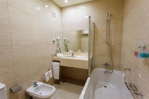 
a bathroom with a sink, toilet and bathtub at Hotel Sao Jorge Garden in Velas

