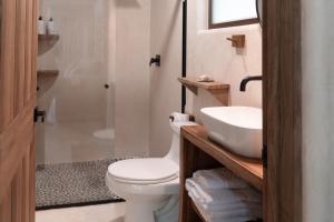 a bathroom with a white toilet and a sink at Hábitat Nandá in La Manzanilla